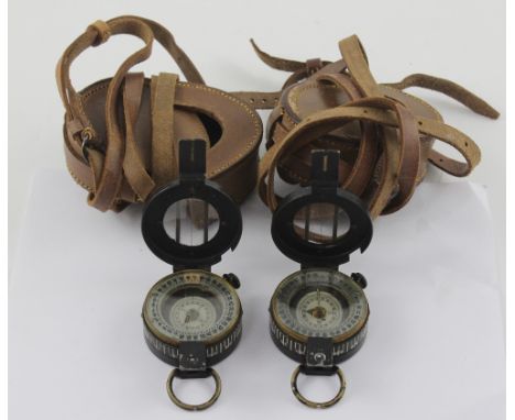 Two WWII military compasses, each in brown leather case with shoulder strap, one stamped with broad arrow and 1944, the other