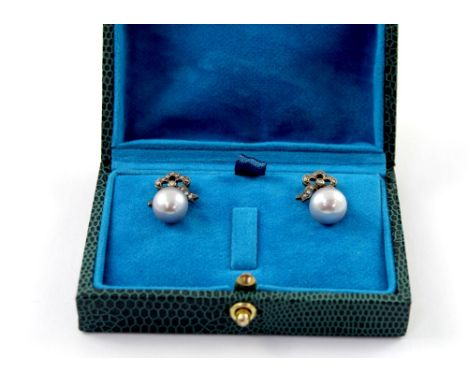 A boxed pair of grey pearl drop earrings with diamond bow tops, approx 5.25g.