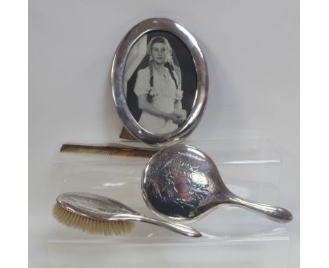 A George V hallmarked silver oval picture frame, Chester 1915 and three pieces of George V dressing table furniture comprisin