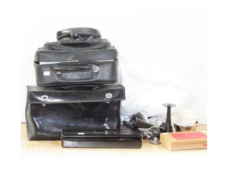 Two mid-20th century black midwives' bags, each with interior metal cases for sterilisation and instruments, three small asso