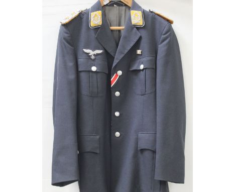 A reproduction German WWII uniform jacket decorated with some original badges, drop 84cm.