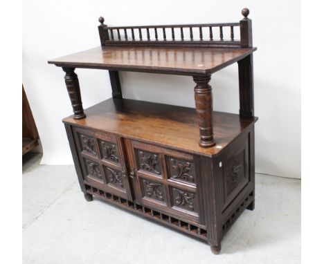 A late Victorian oak buffet with bobbin-turned gallery back and with bulbous turned shelf supports surmounting a carved panel