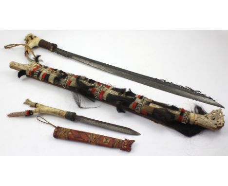 A mid-20th century Diak sabre, from the indigenous tribes in Borneo, with tooled and carved bone handle, scabbard adorned wit