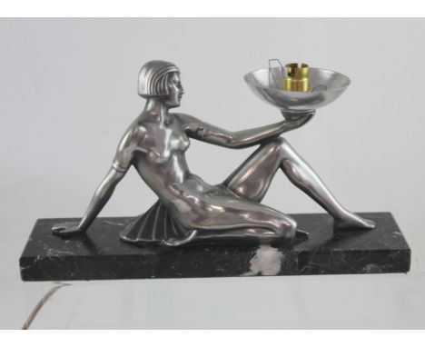 A modern Art Deco style figural table lamp in the form of a reclining female in Egyptian style dress, mounted on black marble