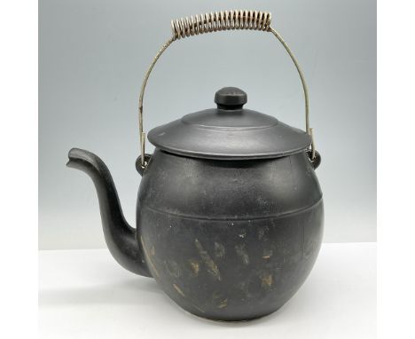 Whimsical design colored in black. Fashioned as a tea kettle with wire handle and round lid. Kookie Kettle embossed but faded