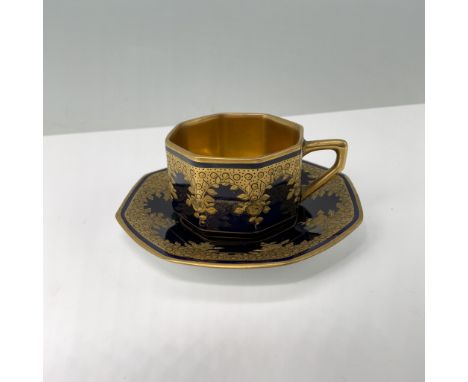 Features an octagonal design with cobalt blue and gold ornate. The cup features a floral and geometric motif in high relief. 