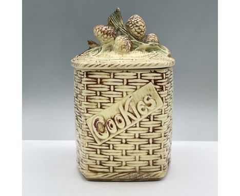 A ceramic woven basket cookie jar with pine cones on the lid. Marked McCoy. 133. Issued: 1957Dimensions: 6.25"L x 6.25"W x 9.