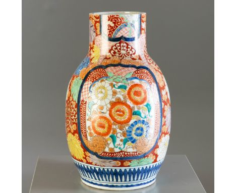 A 19TH CENTURY JAPANESE CERAMIC VASEof baluster form with long neck, with Imari type decoration of flowers heads on a white g