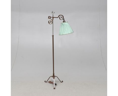 A SWEDISH METAL READING LAMPthe floor standing lamp with pleated shade, on a triform base, fitted for electricity,