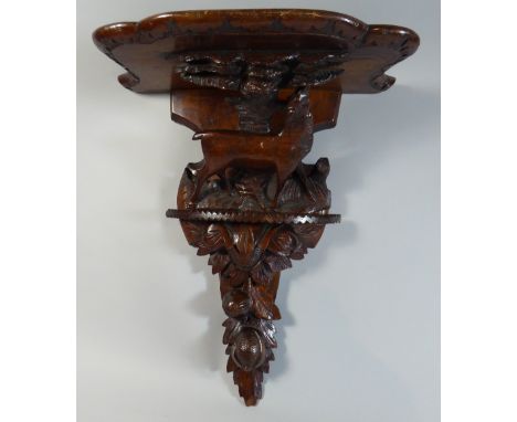 A Black Forest Wall Shelf with Carved Decoration depicting Walnuts and Female Red Deer Beside Tree. 55cm High