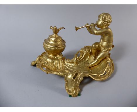 A Gilded Spelter Inkstand with Cherub Playing Trumpet and Inkwell Having Bird Finial to Hinged Lid. Three Scrolled Feet