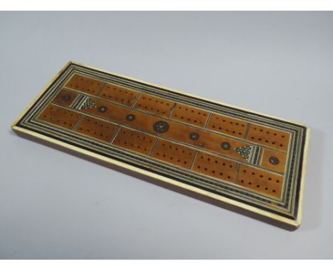 A 19th Century Anglo-Indian Sandalwood Cribbage Board with Bone and Sadeli Mosaic Banding. 27x10cm