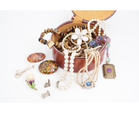 A small quantity of vintage costume jewellery including a white metal charm, a vintage finely carved and painted bone brooch 