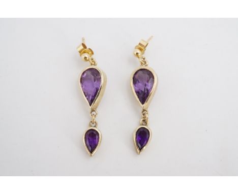 A pair of amethyst and 9 ct gold ear pendants each comprising two bezel set graded pendeloque cut stones, 3.5 cm