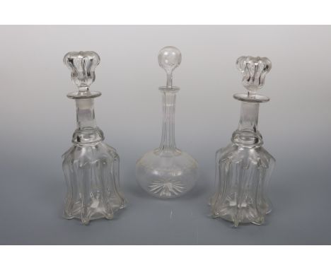 A pair of Victorian glass decanters of ribbed-bell form, together with a shaft and globe decanter