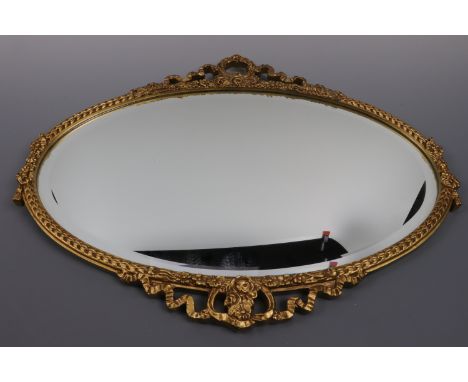 An ornate gilt oval mirror, 60 x 47 cm