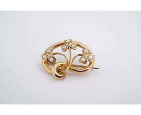 An early 20th Century pearl-set yellow metal brooch in the form of a shamrock spray within a knot, stamped 9 ct, 25 x 18 mm, 