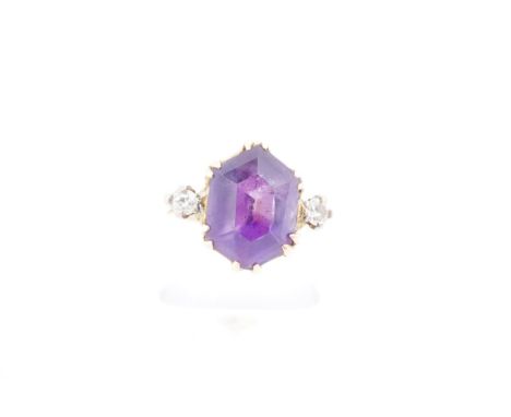 An amethyst and white sapphire dress ring, the hexagonal amethyst (13 x 10 mm) claw-set between two small brilliants on a 22 