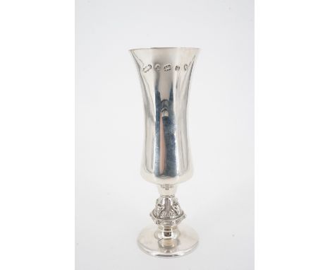 A 1977 silver champagne flute or vase, having a slender waisted bowl and short knopped stem, the latter cast in high relief C