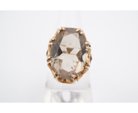 A smoky quartz cocktail ring, the 17 x 12 mm oval stone set on yellow metal shank, M/N