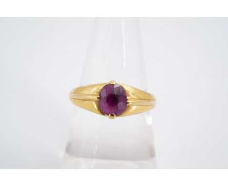 A pink topaz finger ring, the oval stone claw set on a tapering high carat yellow metal shank with pronounced rib, stamped 18