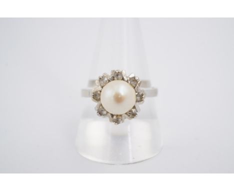 A flowerhead pearl and white stone dress ring, the pearl 7 mm, on a yellow metal shank, R