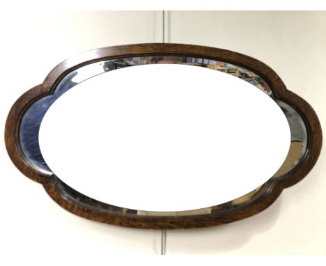 A 1930s cloud form oak framed wall mirror, 73 x 43 cm