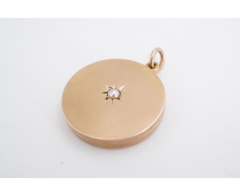 A Victorian yellow metal circular double locket, the front centred by a gypsy-set pearl, 3 cm, 12 g