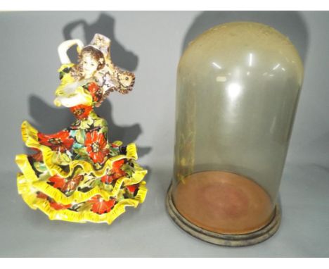 A vintage ceramic model depicting a Flamenco Dancer along with a glass dome and base. [2] This lot must be paid for and colle