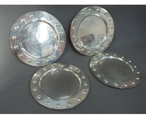 A set of four Mexican sterling silver service plates, plain inner, the borders with embossed detail, each plate 29 cm (diamet