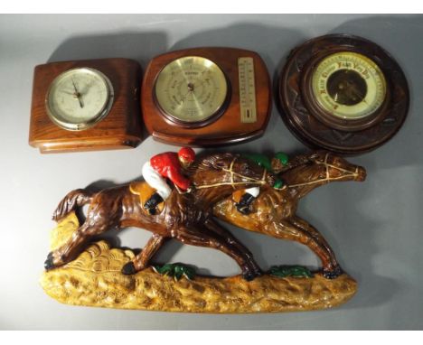 A Comitti of London barometer and temperature gauge, a Smiths Shortland barometer and a further barometer with a carved surro