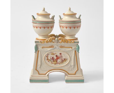 Glazed and enameled earthenware.In the form of two handled urns on a plinth, enamel-decorated with pastoral scenes.Impressed 