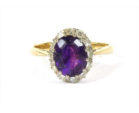 A gold amethyst and diamond cluster ring, with an oval mixed cut amethyst, twelve claw set to surround of eight cut diamonds,