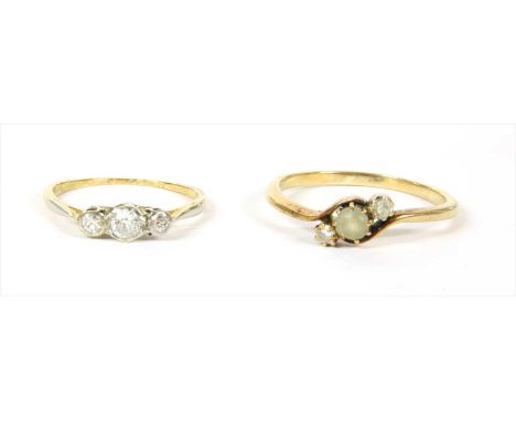 A gold three stone diamond ring, an old European cut diamond with a smaller Swiss cut diamond at each side, grain set to tape