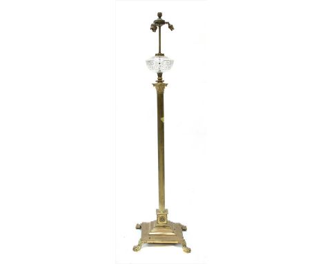 A brass corinthian column oil lamp, converted to electricity, with a cut glass reservoir, on paw feet