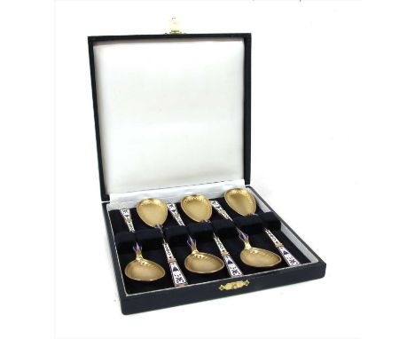 A cased set of Danish gilt silver and enamel teaspoons , by Peter Hertz, Copenhagen, with a blue and white enamel design to t