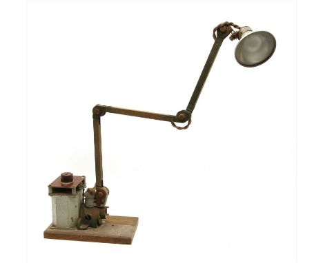 An industrial desk work lamp, with adjustable arm and transformer on wooden base
