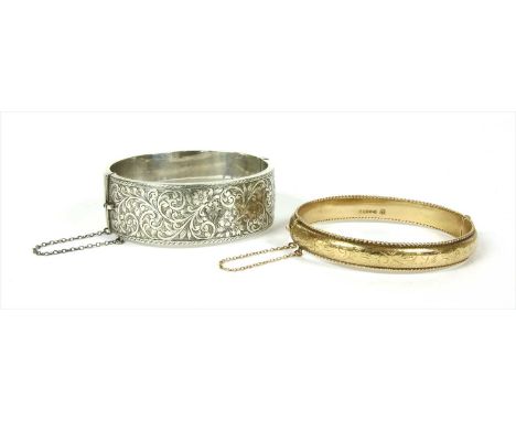 A 9ct gold hollow hinged bangle, with scrolling hand engraved decoration and twisted wire guards, to concealed box clasp and 