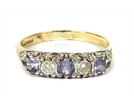 A 9ct gold tanzanite and diamond five stone ring, with a graduated row of alternating circular mixed cut tanzanites and brill