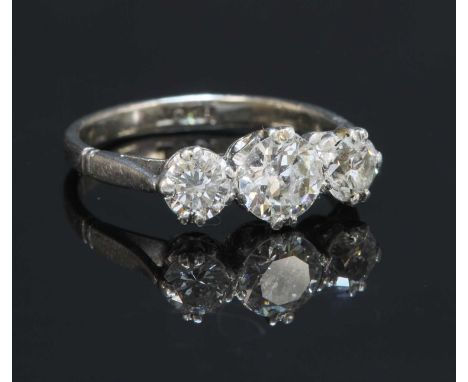 A white gold three stone graduated diamond ring, with a brilliant cut diamond at the centre and a smaller brilliant cut diamo