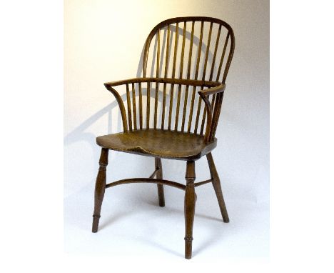 A stick back armchair with elm seat on turned legs with crinoline stretchers