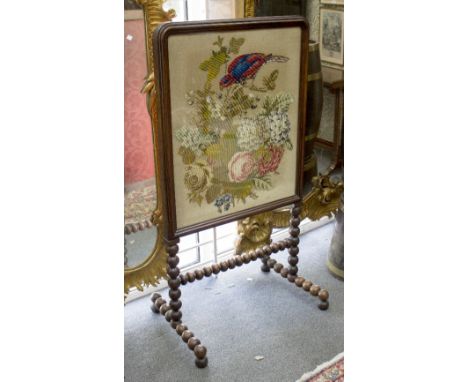 A Victorian rosewood fire screen, the glazed screen with gros point needlework panel depicting a parrot within foliage, raise