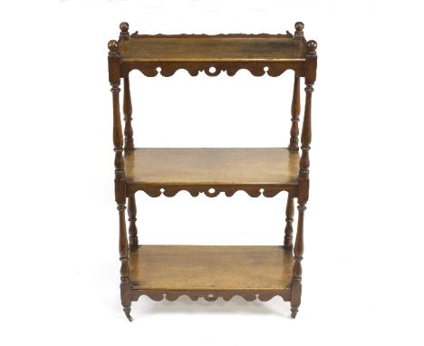 A mahogany three-tier whatnot with scroll and pierced apron to each shelf, on turned baluster supports, 59cm wide