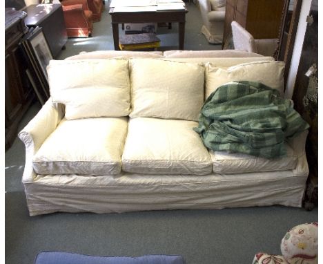 A three-seater sofa, with green striped loose cover