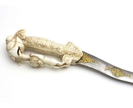 A khanjar dagger, with wavy blade gilt decorated, the ivory carved handle in the form of an Indian elephant its trunk being a