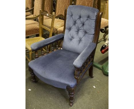 A 19th Century button back upholstered open armchair, on turned supports and castors