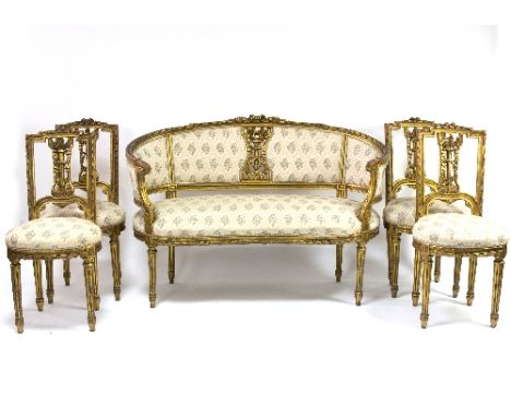 A French late 19th Century carved giltwood salon suite in the Louis XVI style, comprising a canape and four chairs, the frame