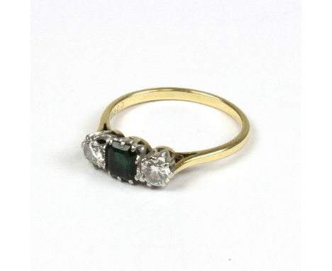 An emerald and diamond dress ring to an 18ct gold band, set with a step cut emerald to the centre flanked by a single brillia