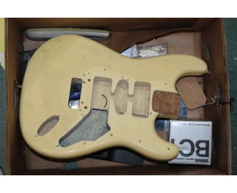 A box of assorted musical items including a cream lacquered guitar body, switches etc.