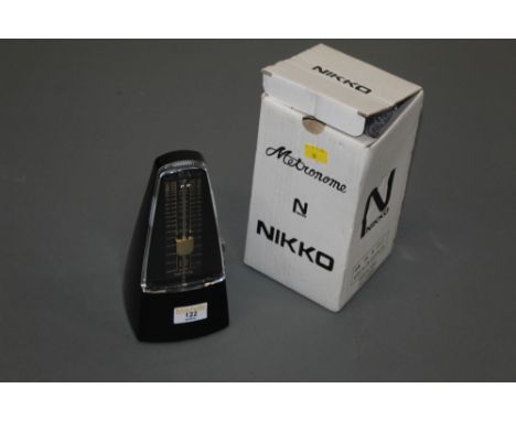 A Nikko black plastic metronome, as new.  Height 21 cm, boxed.